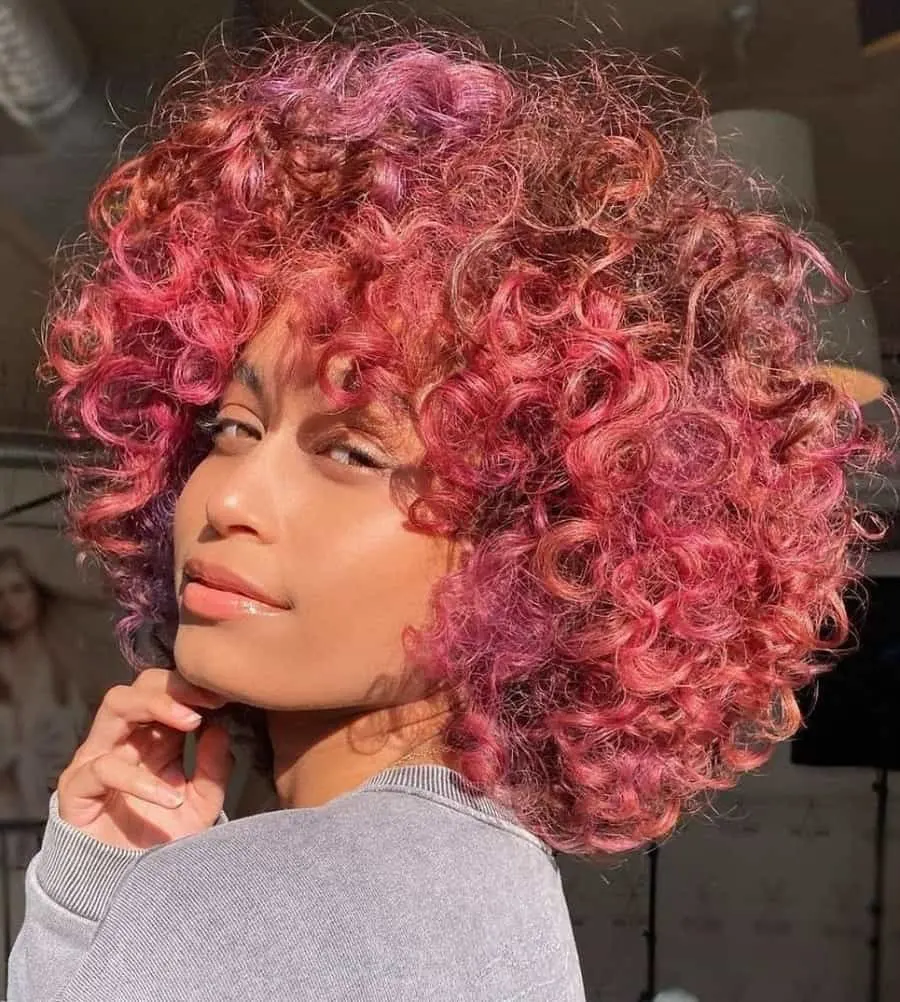 black girl with curly pink bob hairstyle