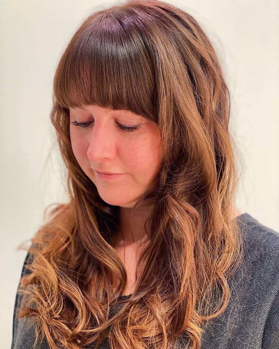 curly brown hairstyle with thick bangs