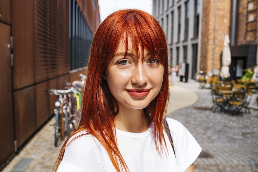 woman with low maintenance long red hairstyle with bangs
