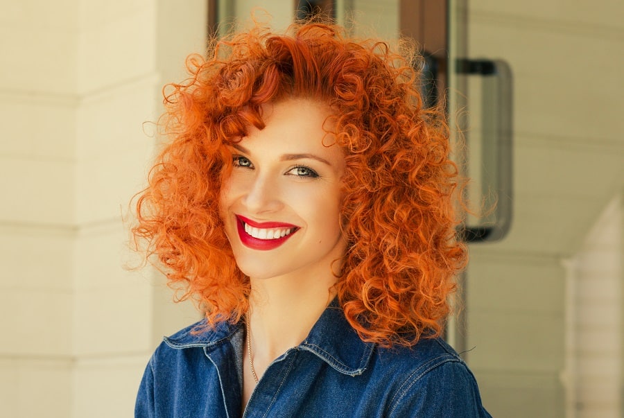 woman with red blunt curly hairstyle