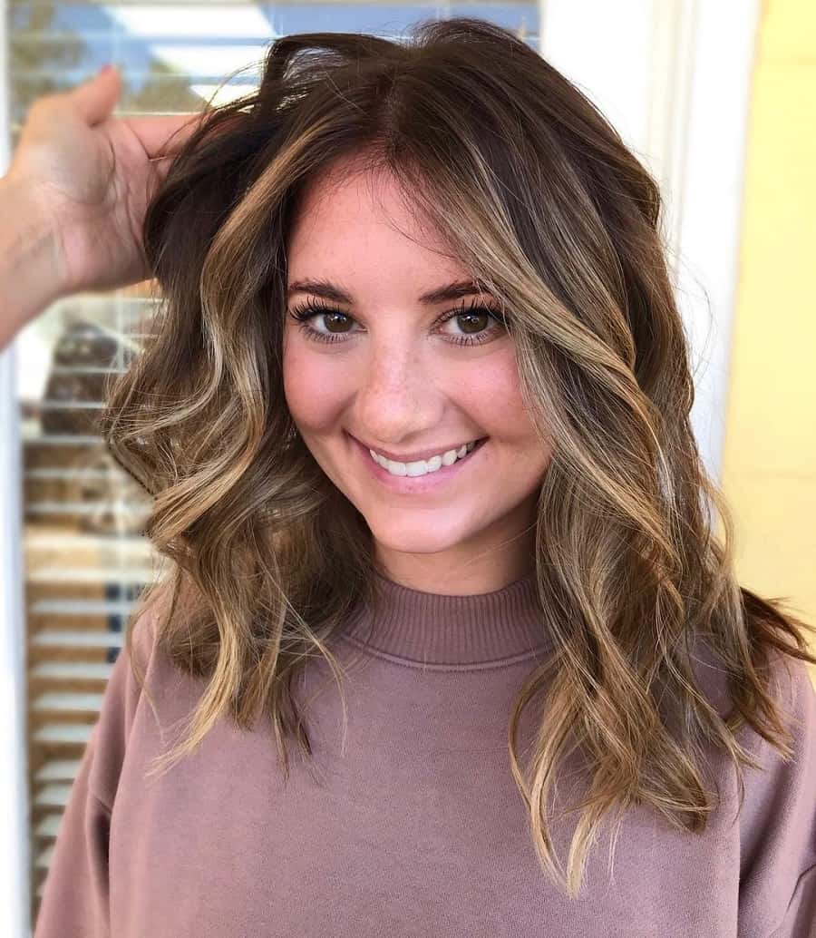 round face woman with medium wavy hair and highlights